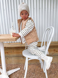 5 year old child wearing an organic cotton striped jumper and pants with a brown puffer vest and white Bobby G branding and cotton knit beanie in a neutral colour-way. 