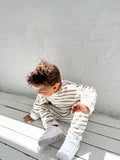 2 year old boy wearing an oversized striped jumper and drop crotch pants in green and white stripes available in baby, toddler and kids sizes with Bobby G branding tags