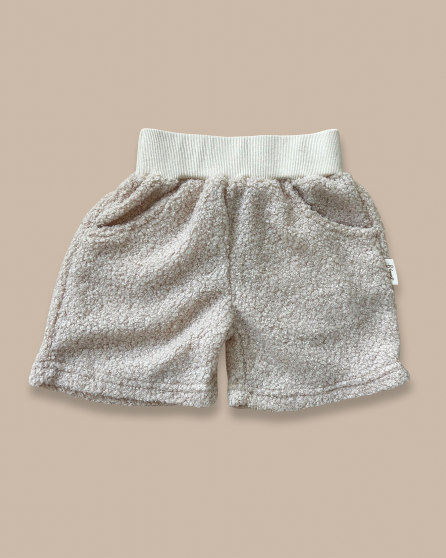 Kids teddy cotton shorts featuring a ribbed elasticated waistband and Bobby G branding with two pockets. 
