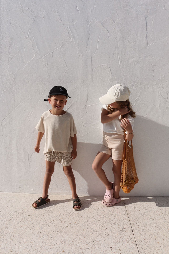 Brother and sister wearing neutral coloured clothing in Summer 